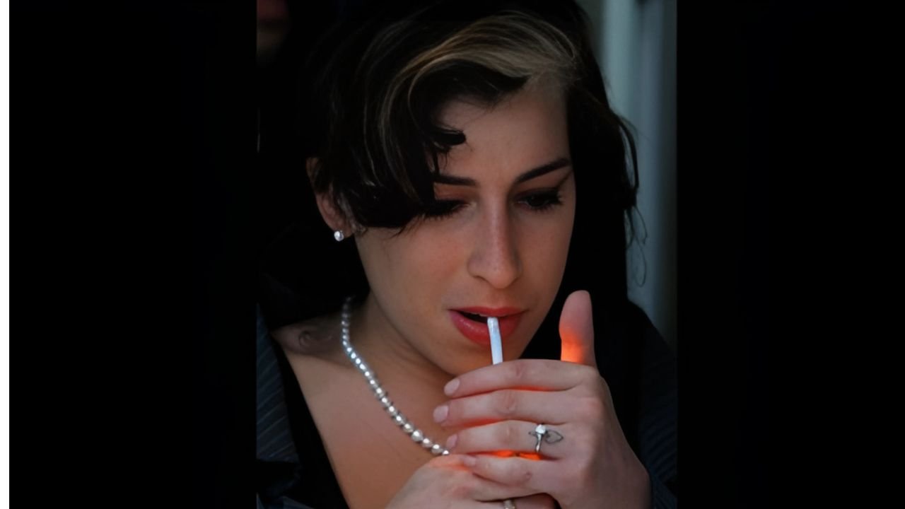Young Amy Winehouse performing during the 'Frank' era, cigarette in hand, raw and focused